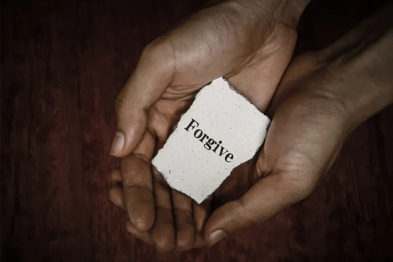 cupped hands holding note to forgive